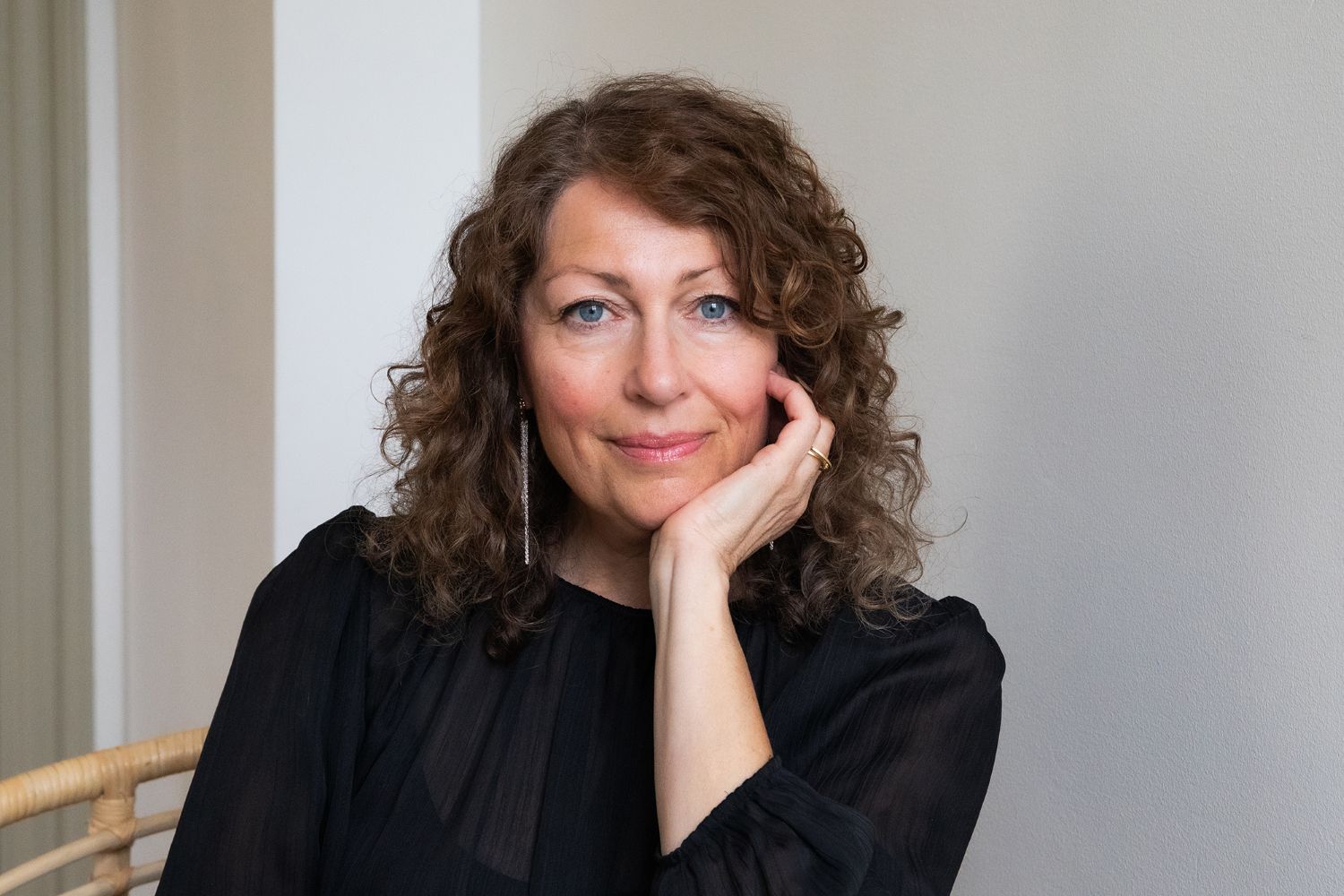 Elisabeth Åsbrink gazing at camera with her head resting on her hand