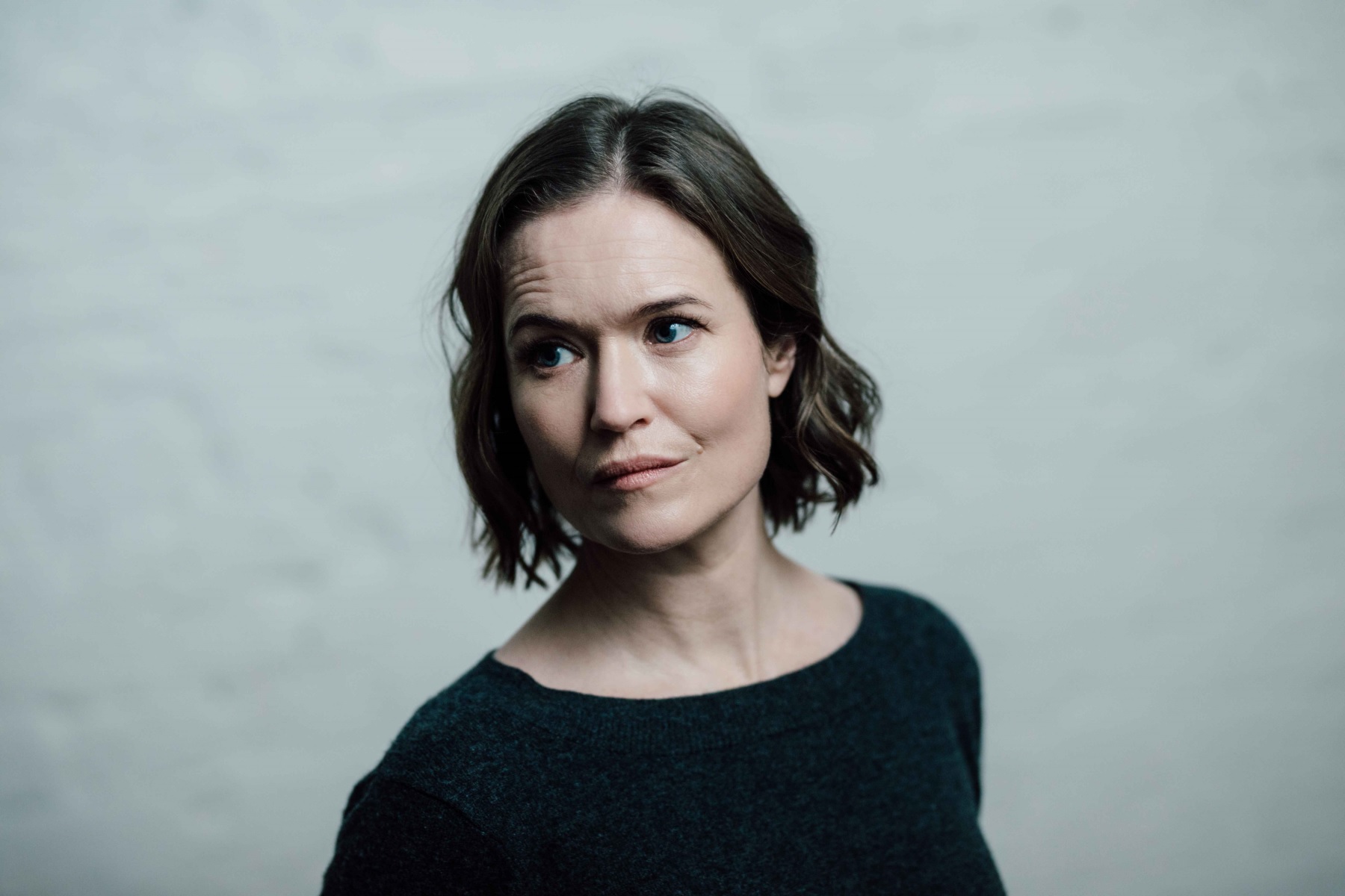 Matilda Gyllenberg in black top against a grey background looking to one side.