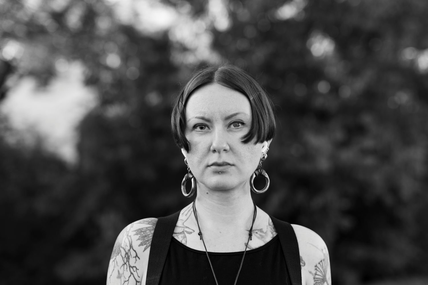 Iryna Shuvalova in black top in front of trees.