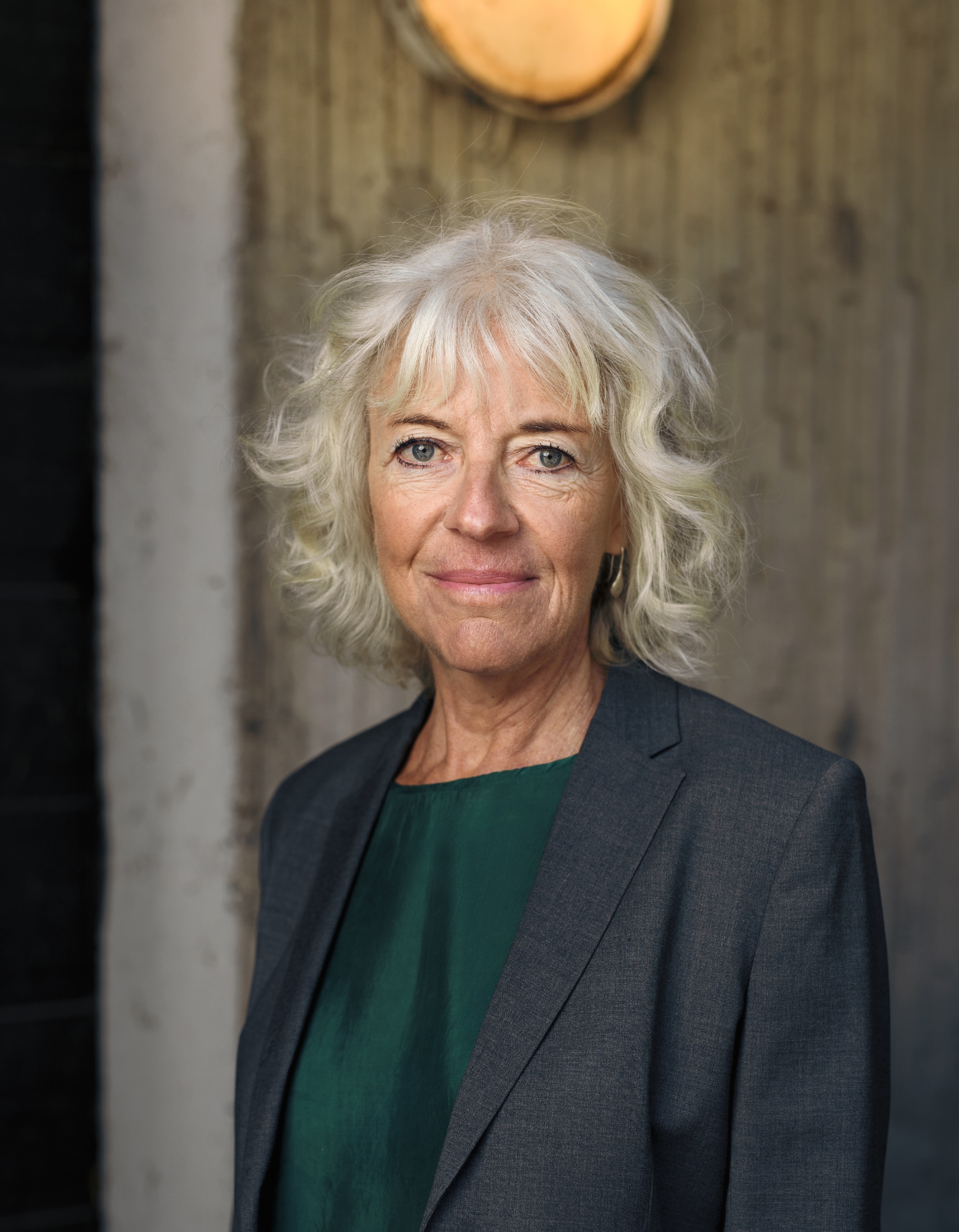 Grey-haired woman smiles at the camera in doorway