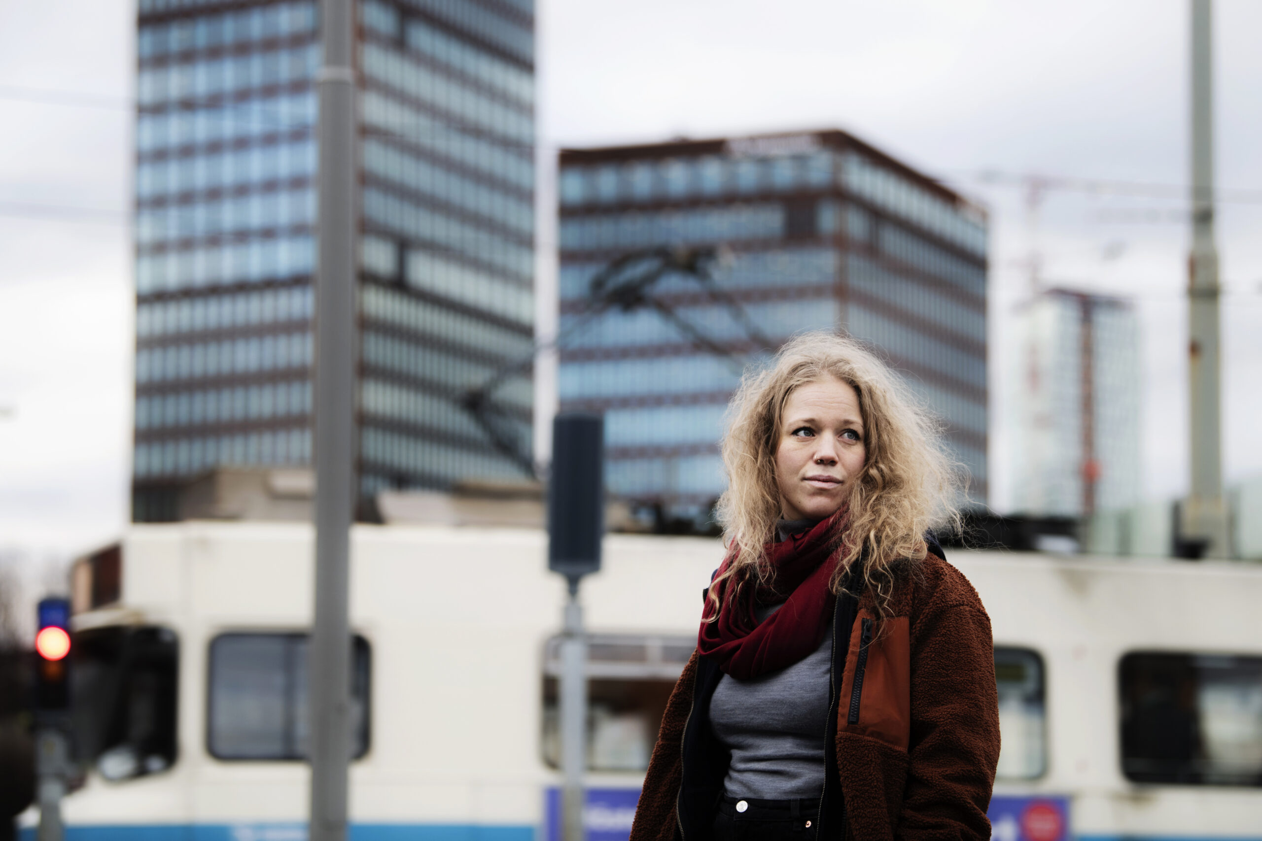 Olivia Bergdahl in front of tower blocks in red scarf