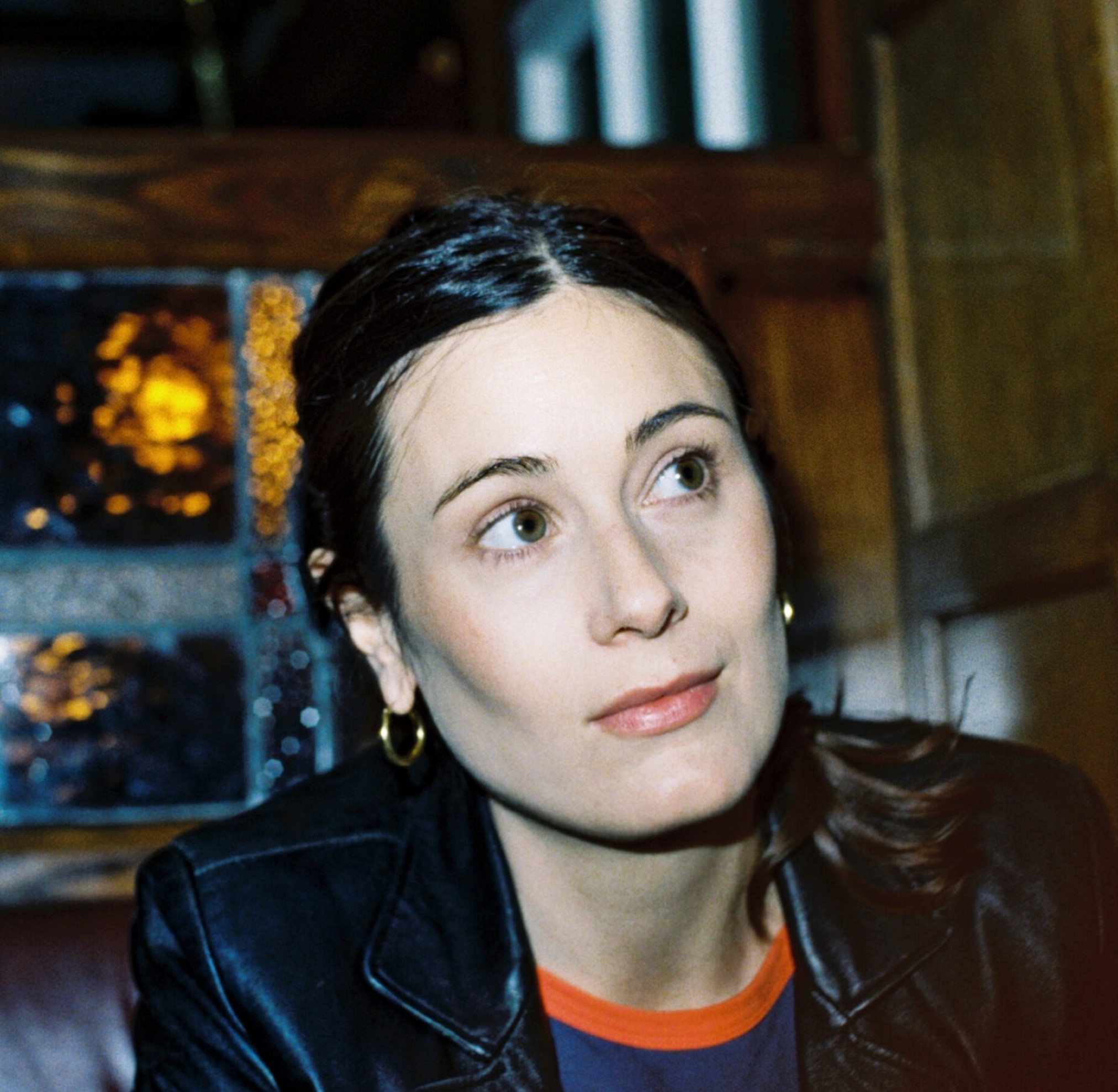 Author portrait Zara Uzun Kjellner against wooden wall