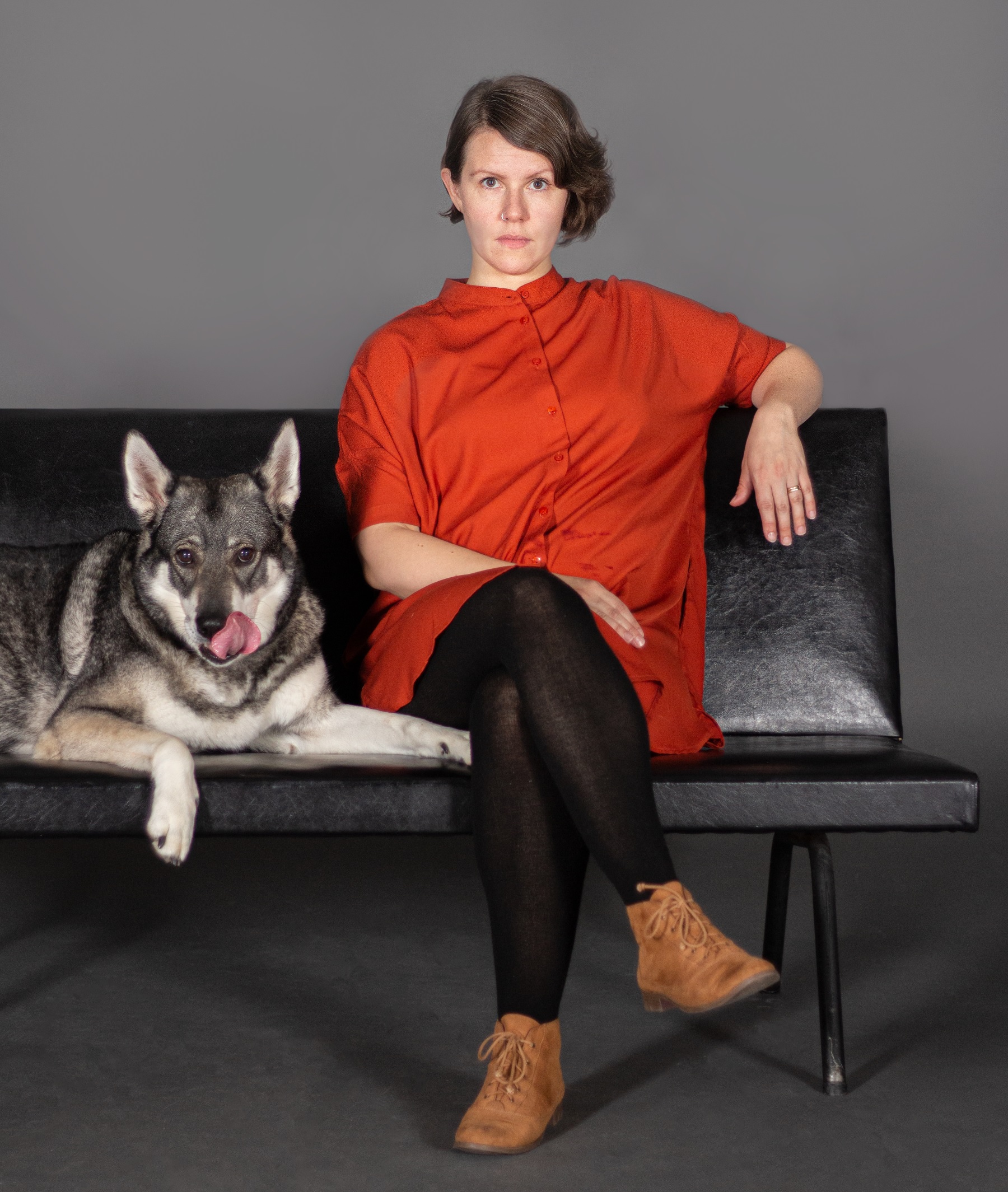 poet Emma Ahlgren sitting on sofa next to dog.
