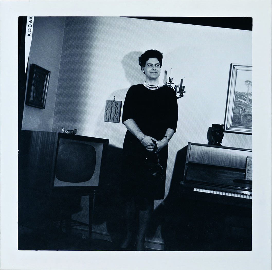 Eva-Lisa standing in black dress and pearls.