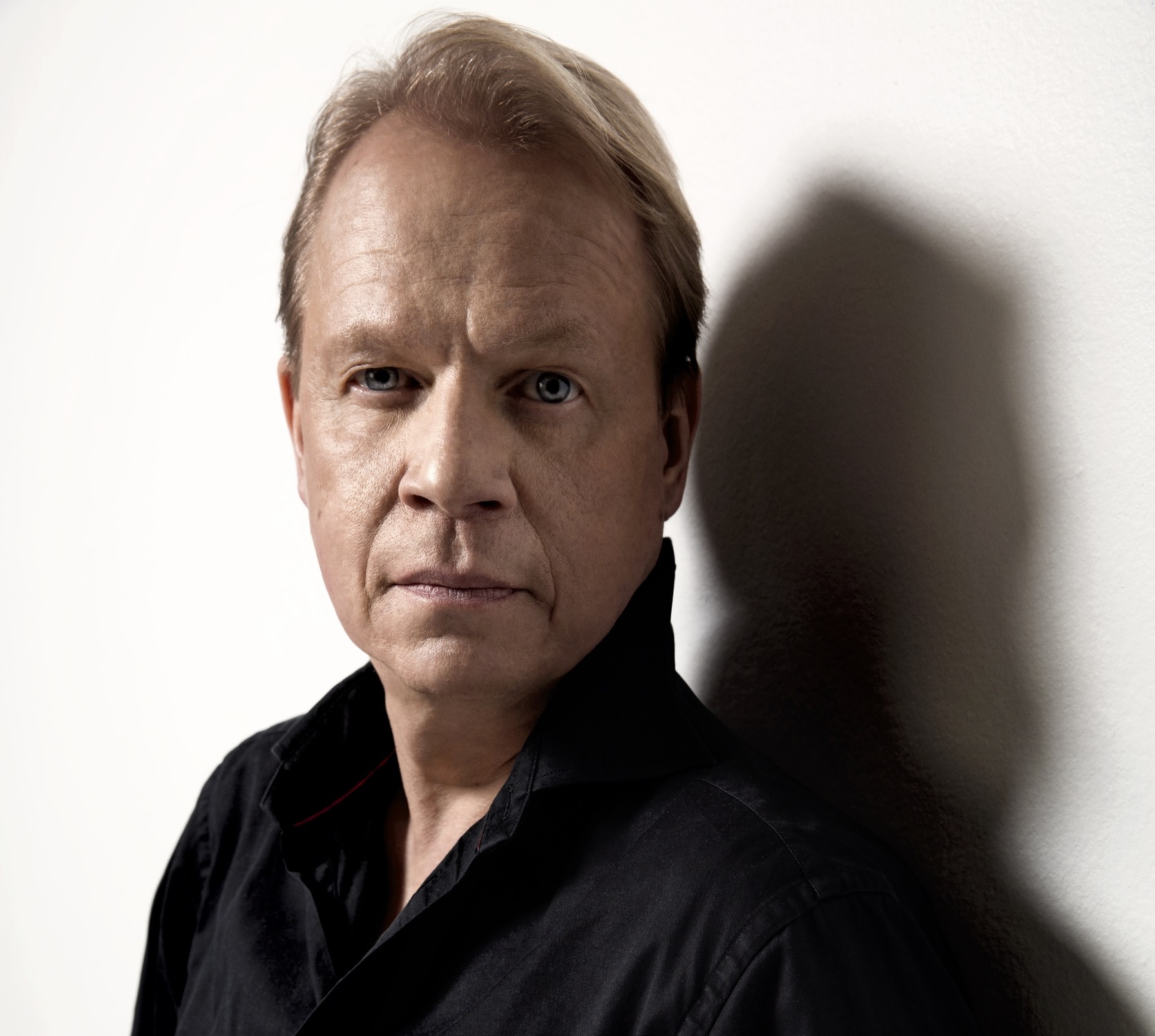 Peter Sandström in a black shirt against a white background.