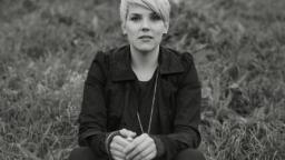 Andrea Lundgren sitting in grassy meadow.