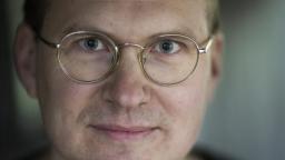 Close-up image of fair-haired man in glasses