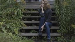 Sara Gordan sitting on steps among greenery