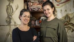 Malin Klingenberg and Maria Sann in front of images of the human skeleton