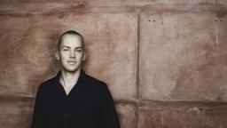 Erik Petersson standing in front of red stone wall