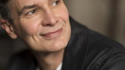 Johan Ehn looking over his shoulder smiling, in close-up.