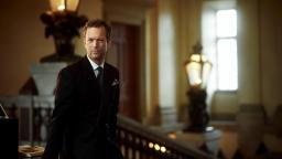 Niklas Natt och Dag in a suit standing in front of historic staircase