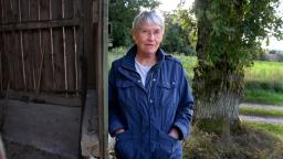 Ingela Strandberg in jacket standing next to barn door.