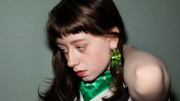 Alva Hedlund in semi-profile wearing green scarf and earrings