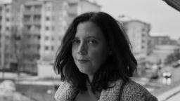 Elise Karlsson standing on balcony with tower blocks in the background.