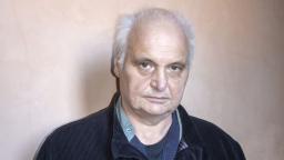 Göran Greider standing in front of orange wall