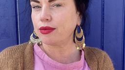 Author photo of Linda Spåman sitting in front of blue background.